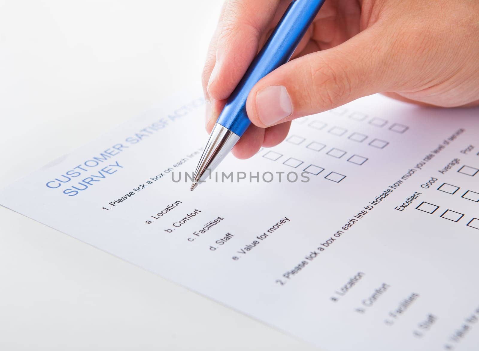 Close-up Of A Person Filling Survey Form With Pen
