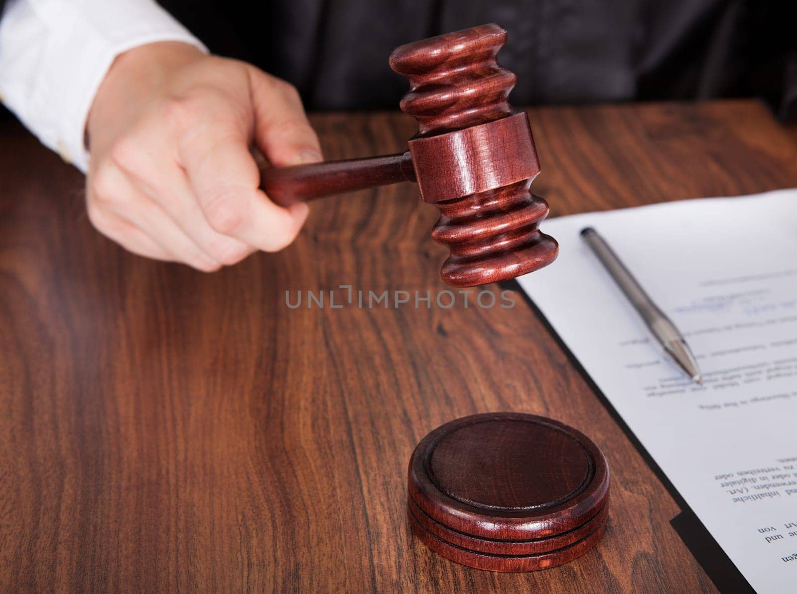 Close-up Of Male Judge Hand Striking The Gavel In A Courtroom