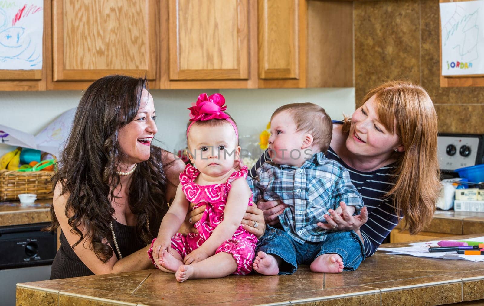 Mothers in kitchen pose with their babies