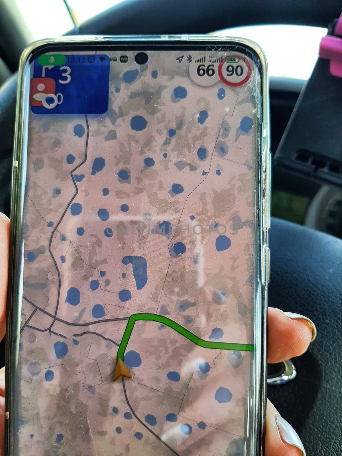 Hand of woman holding cell phone Smartphone with location in map online. Route in nature with many lakes on the map. Norway. Finland. Karelia in Russia