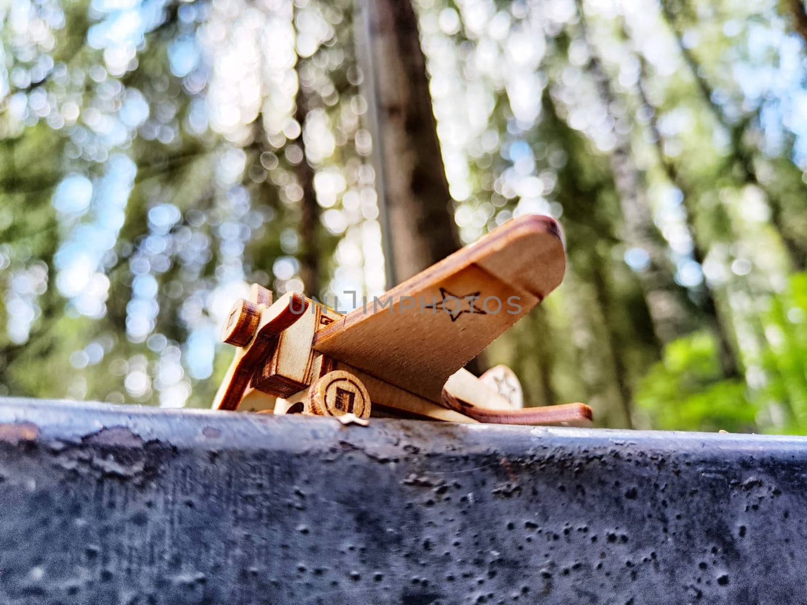 Vintage toy wooden airplane with stars on wing on nature. Plane crash, breakdown. Old Soviet glider from USSR of Soviet Union. Military aircraft from World War II and the Great Patriotic War of Russia