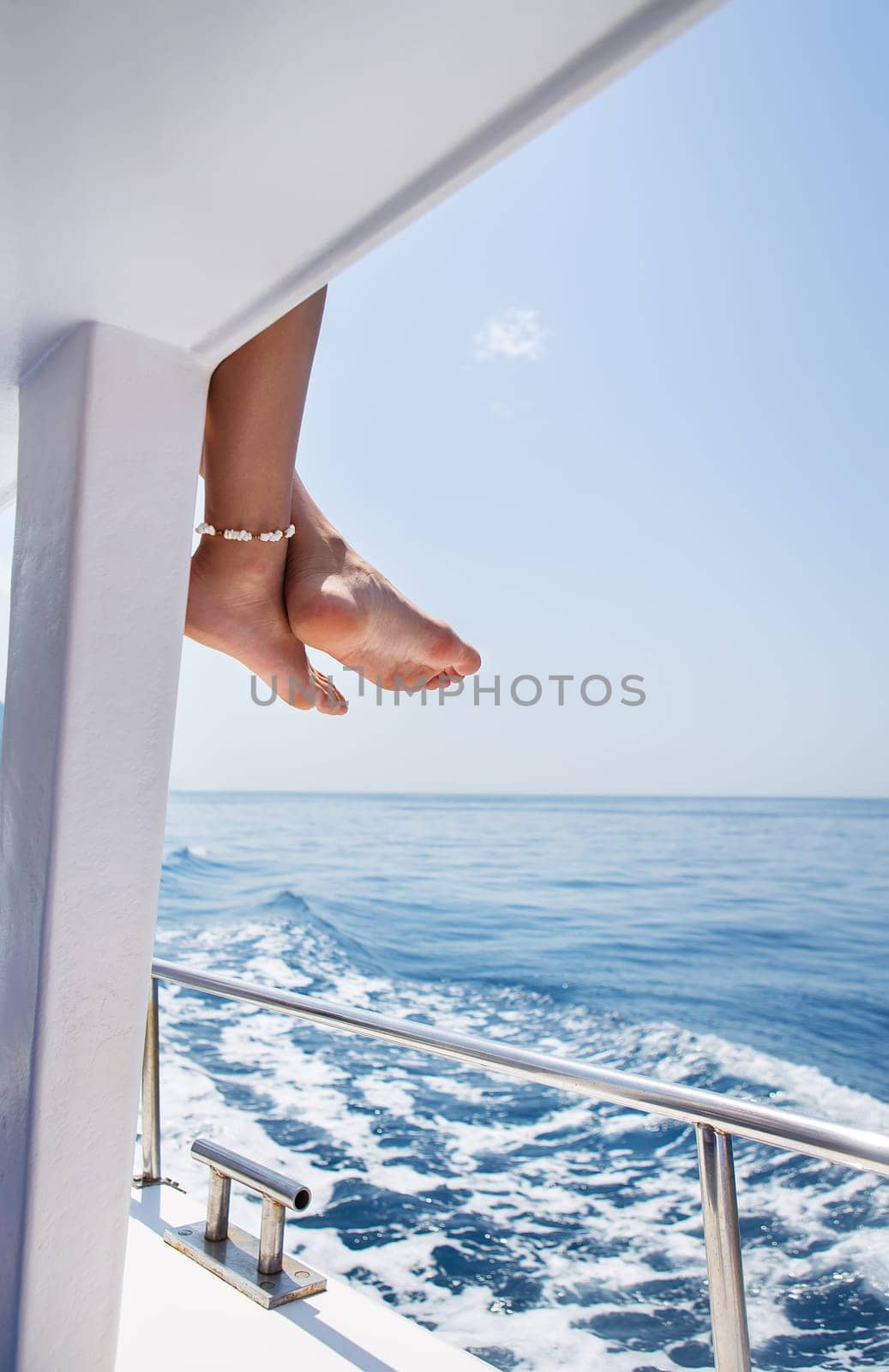 Close-up of beautiful sexy female legs on a yacht, sailing on a yacht, summer vacation, conceptual image of pleasure and enjoyment. by sfinks