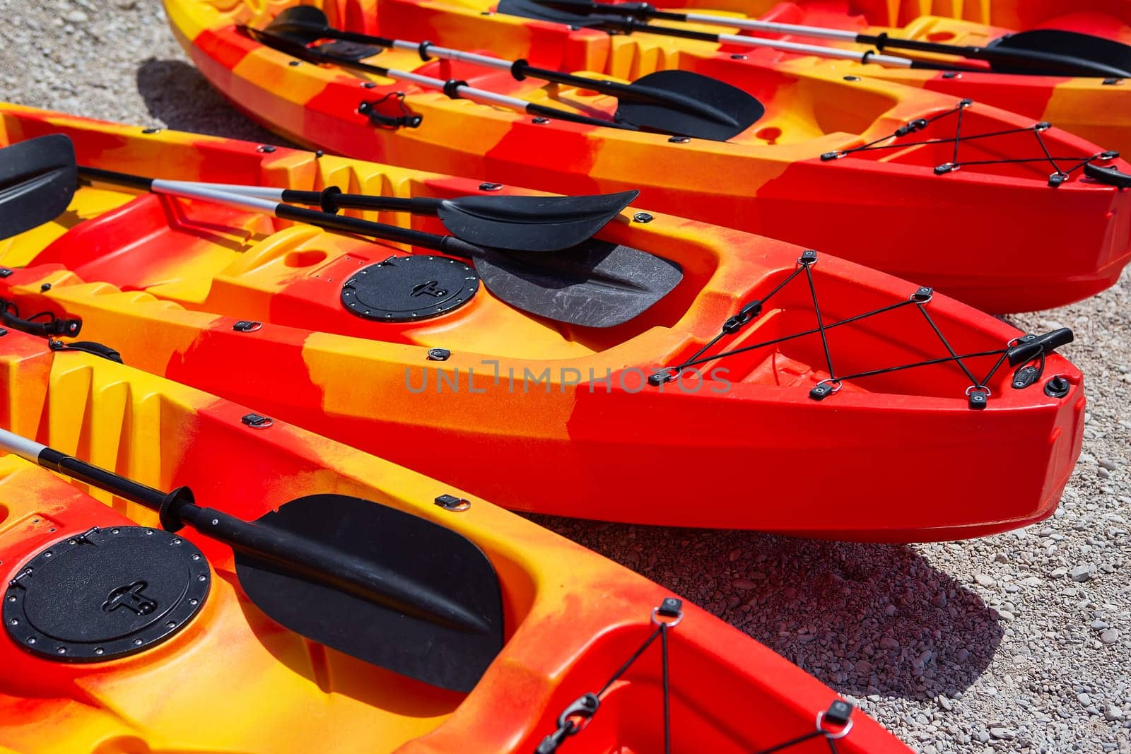Leisure activities, sports, kayaking. Boat for water rafting. There are several bright orange kayaks on the sandy beach