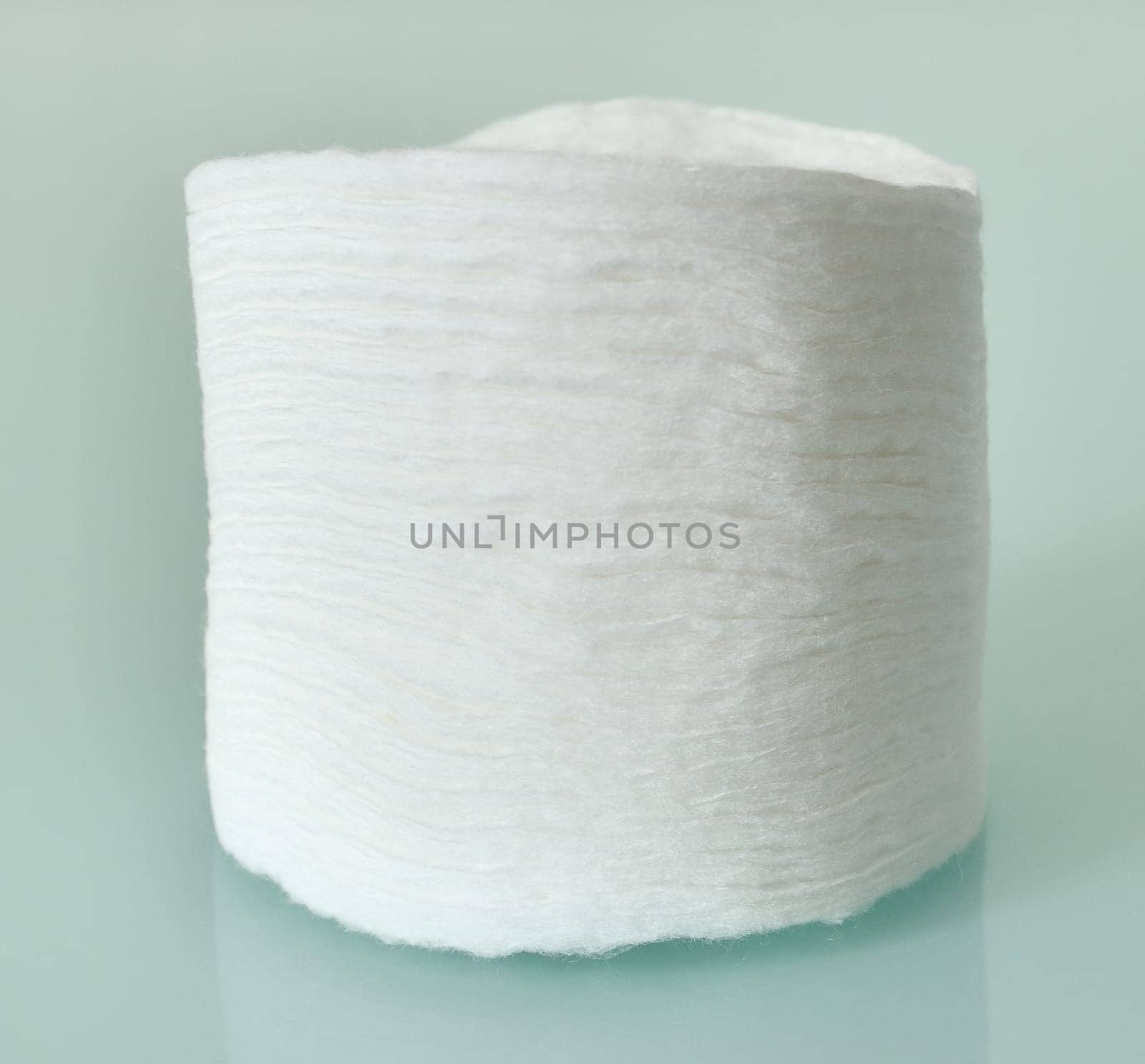 Stack of Cotton disks on light blue background by olgavolodina