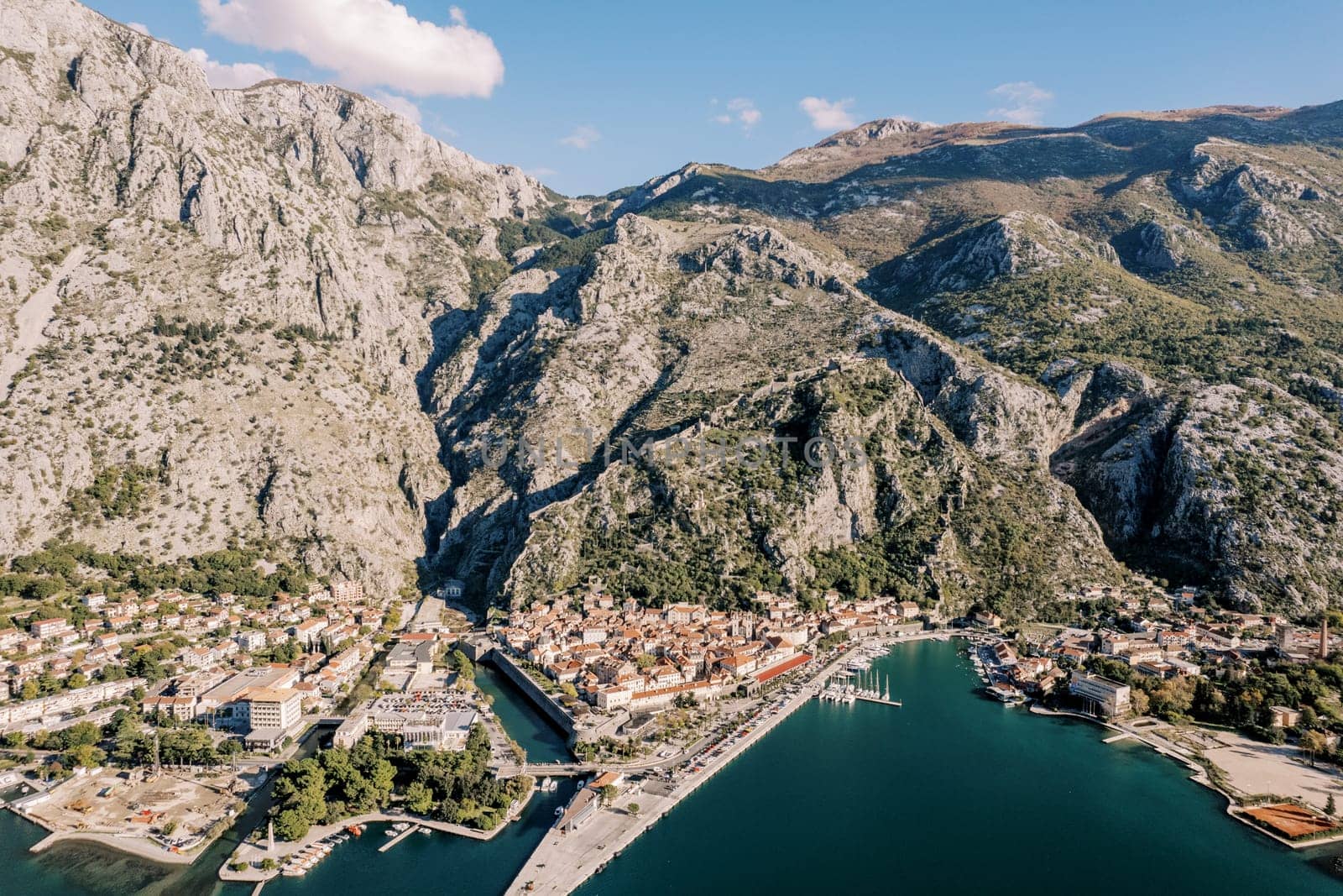 Old town of Kotor with narrow canals at the foot of the mountains on the seashore. Montenegro. Drone. High quality photo
