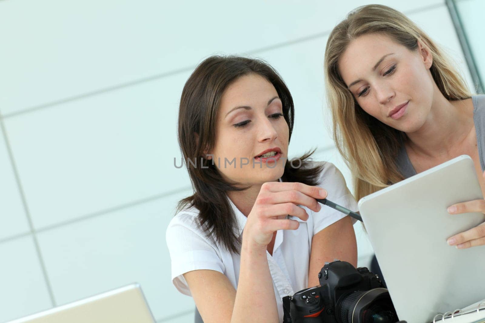 Women photographers working in office with tablet