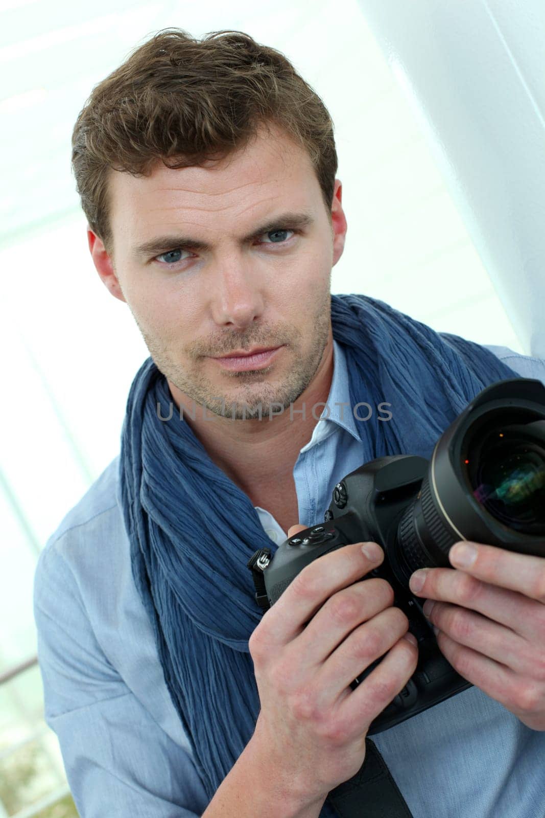 Handsome guy holding photo camera