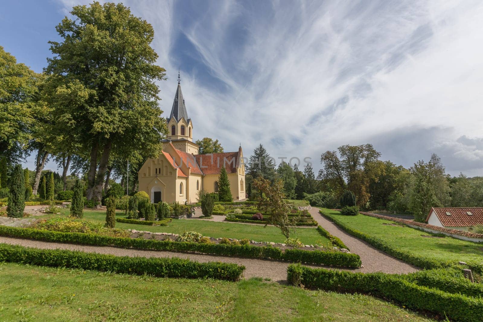 Cemetery with small yellow church in Tranekér