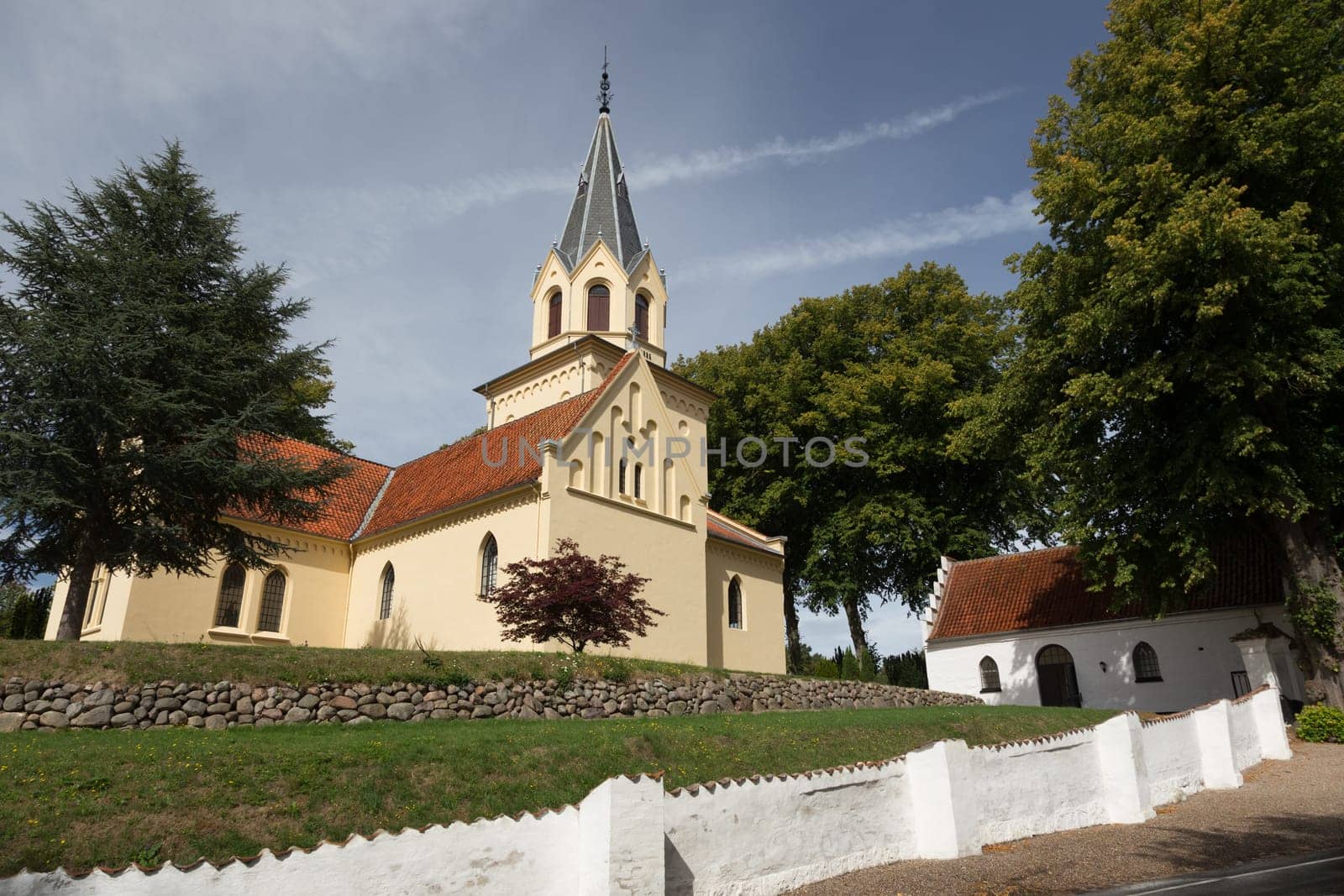 Yellow church cemetery behind white wall