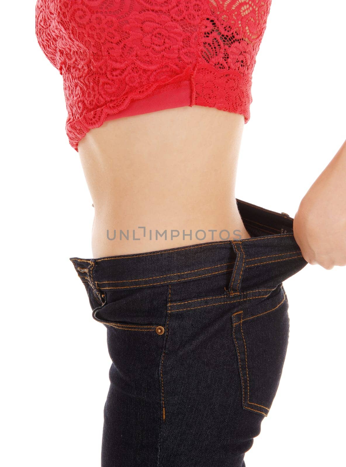 A young woman standing in profile, showing her weight loss in her jeans,.a body part picture, isolated on white background..
