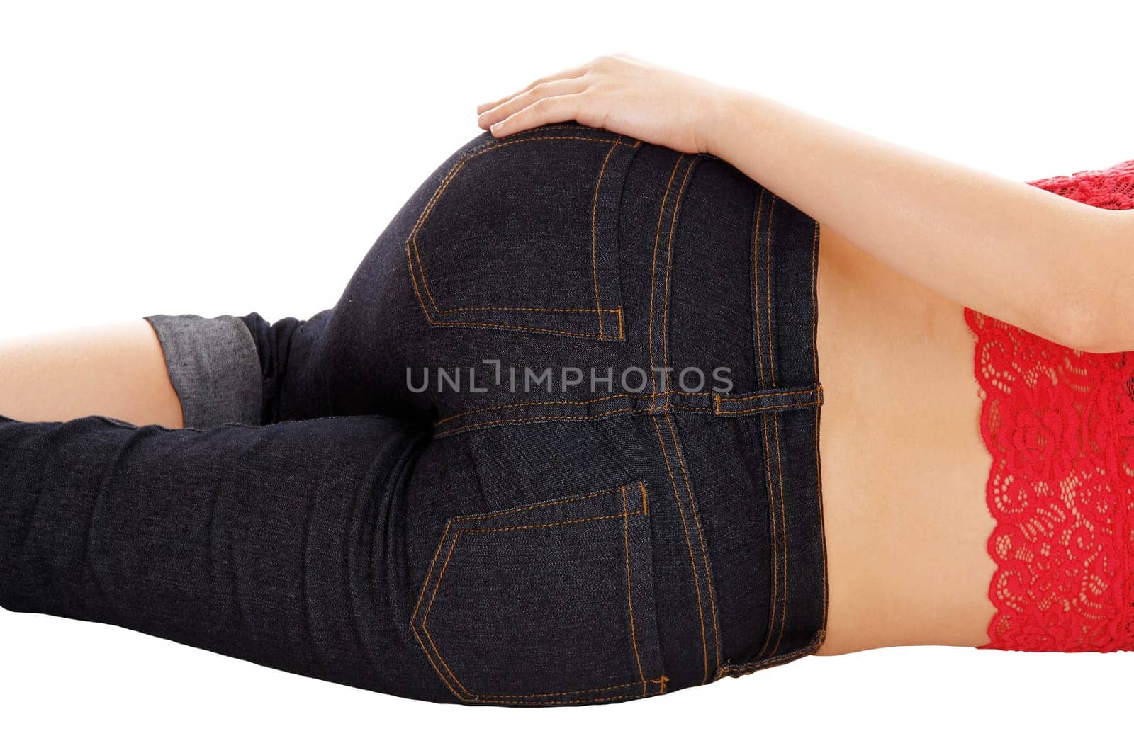 The butt of a young woman lying on the floor in jeans with her hand on her.hip, isolated for white background..