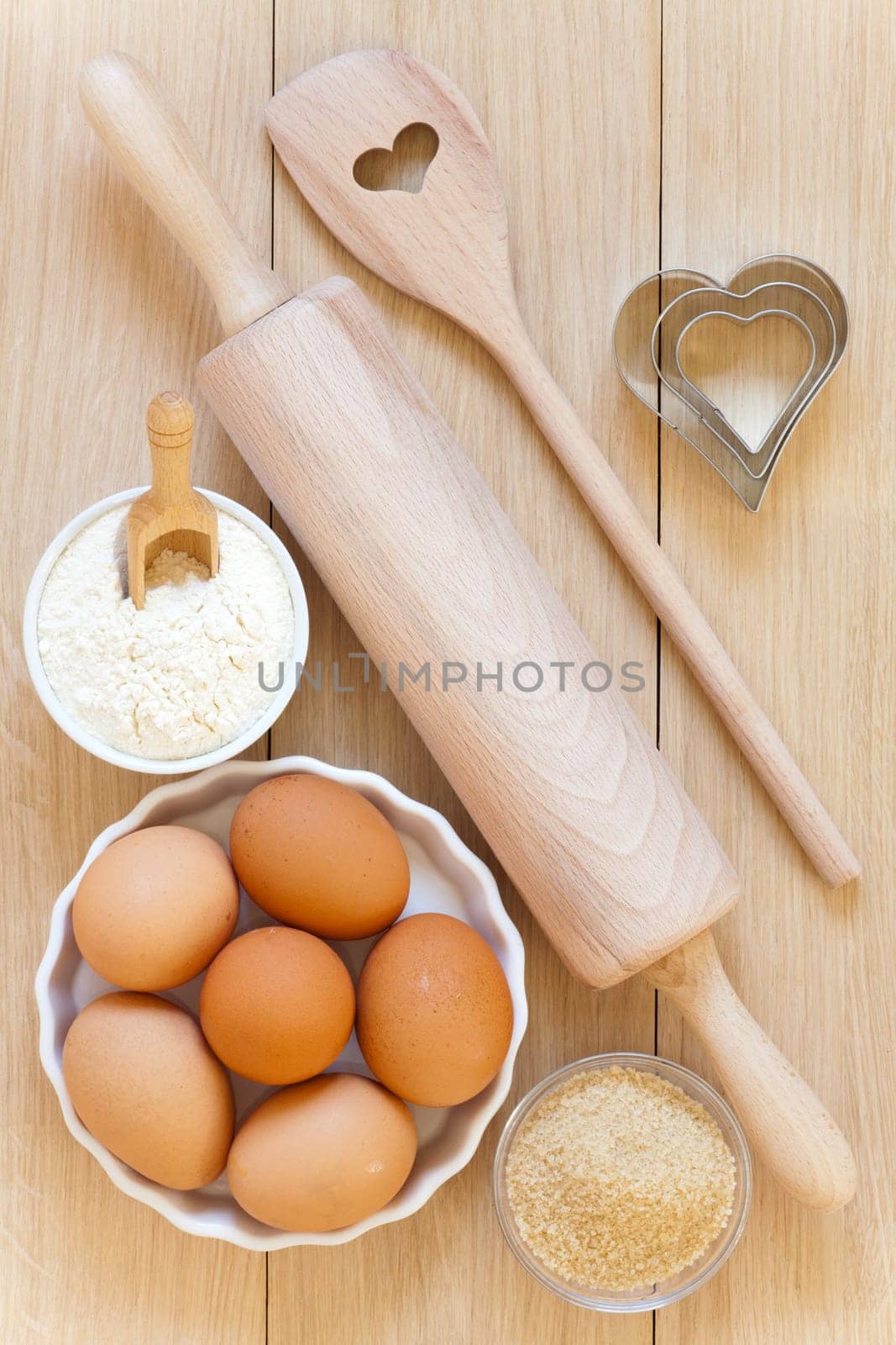 Flour,sugar,eggs and baking utensils on a wooden table