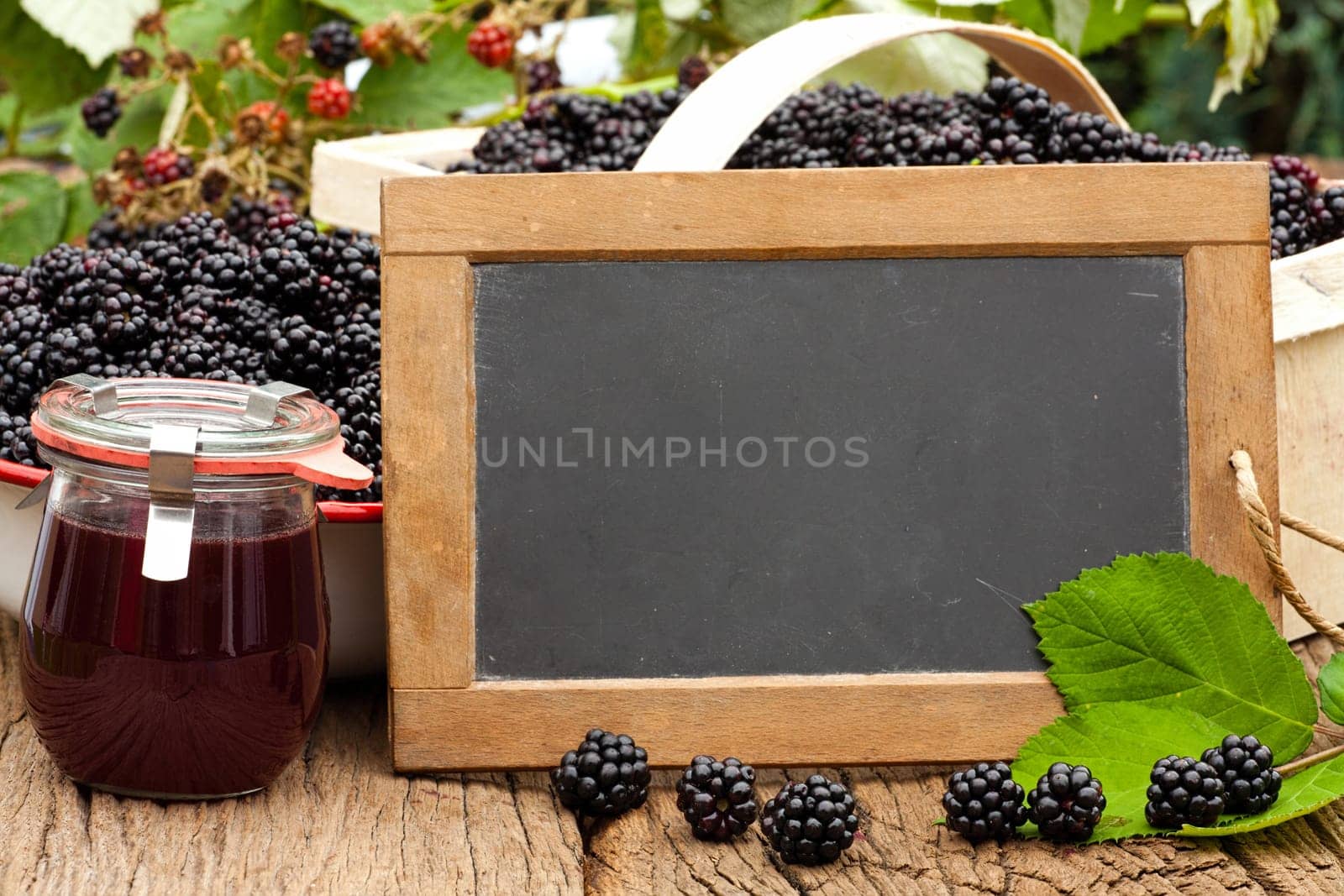 Slate board with text area in front of blackberries and jelly