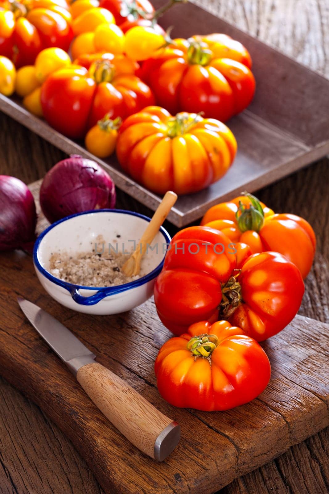 Meat tomatoes,salt bowl with spoon and a knife