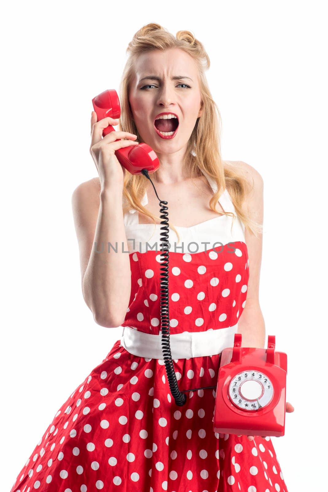 a woman in a rockabilly dress roars into a red phone handset