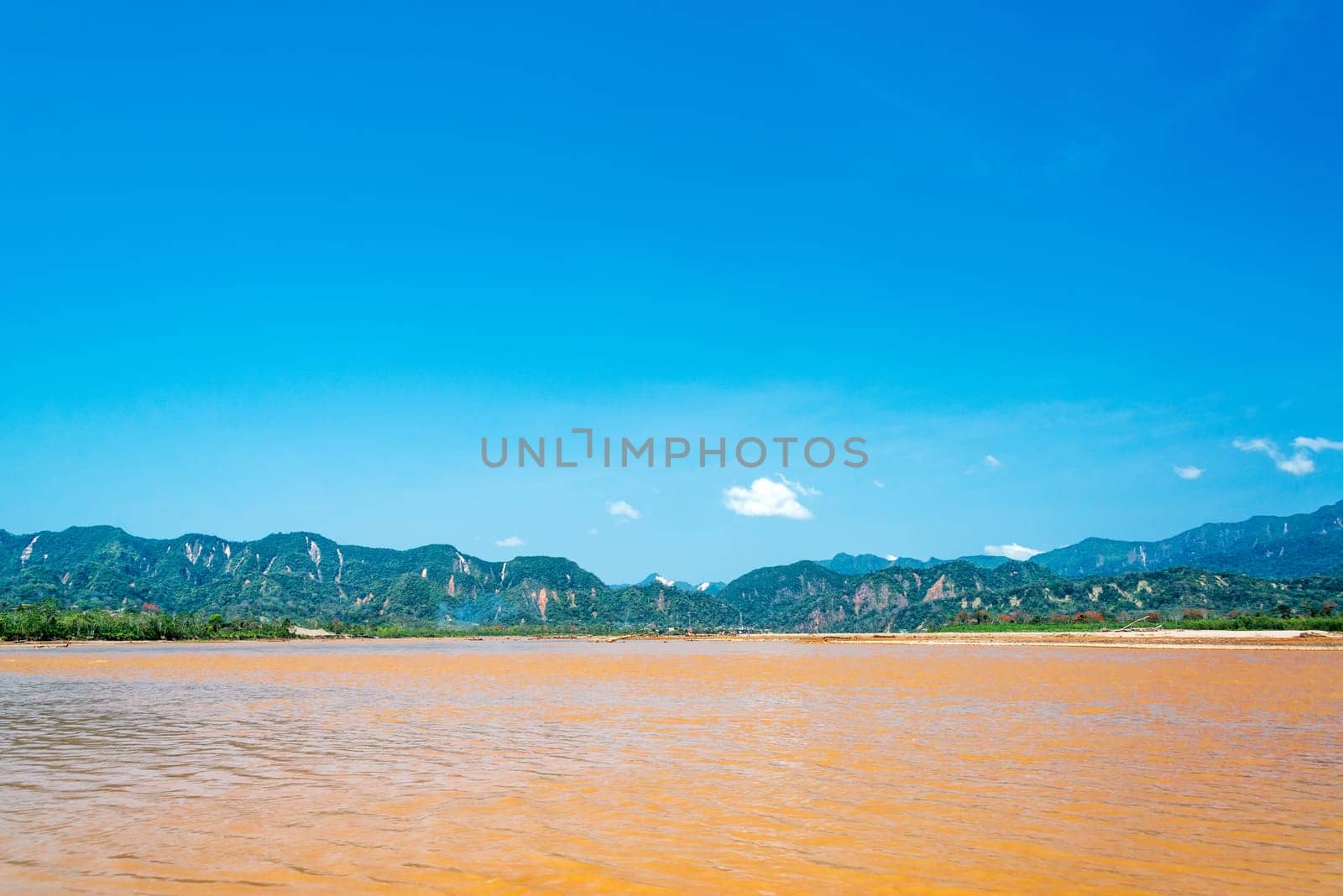 View of the Beni River with lush green hills in the background near Rurrenabaque, Bolivia