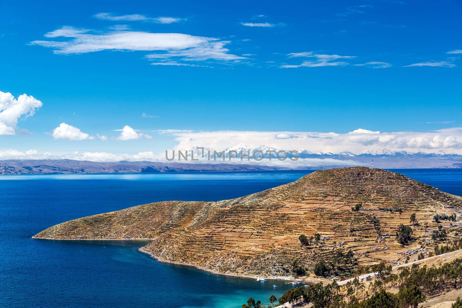 Terraced landscape of Isla del Sol with Andes mountains in the background on the Bolivian side of Lake Titicaca