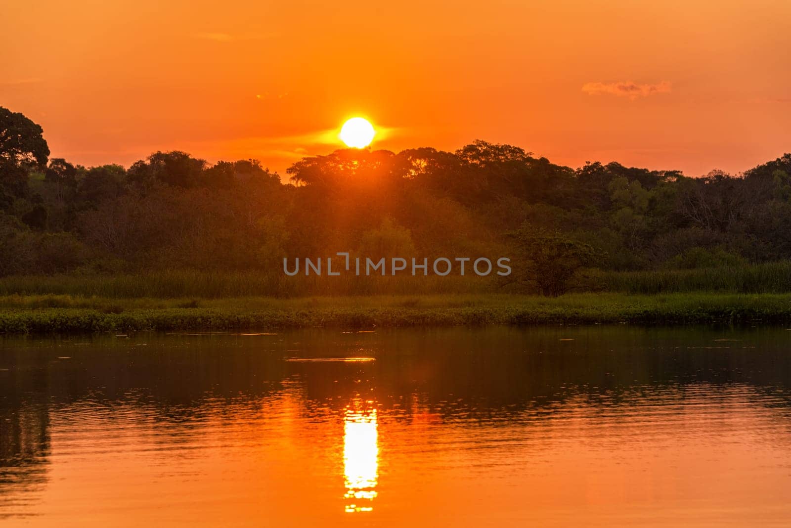 Red and orange sunset over a lake in Madidi National Park in Bolivia
