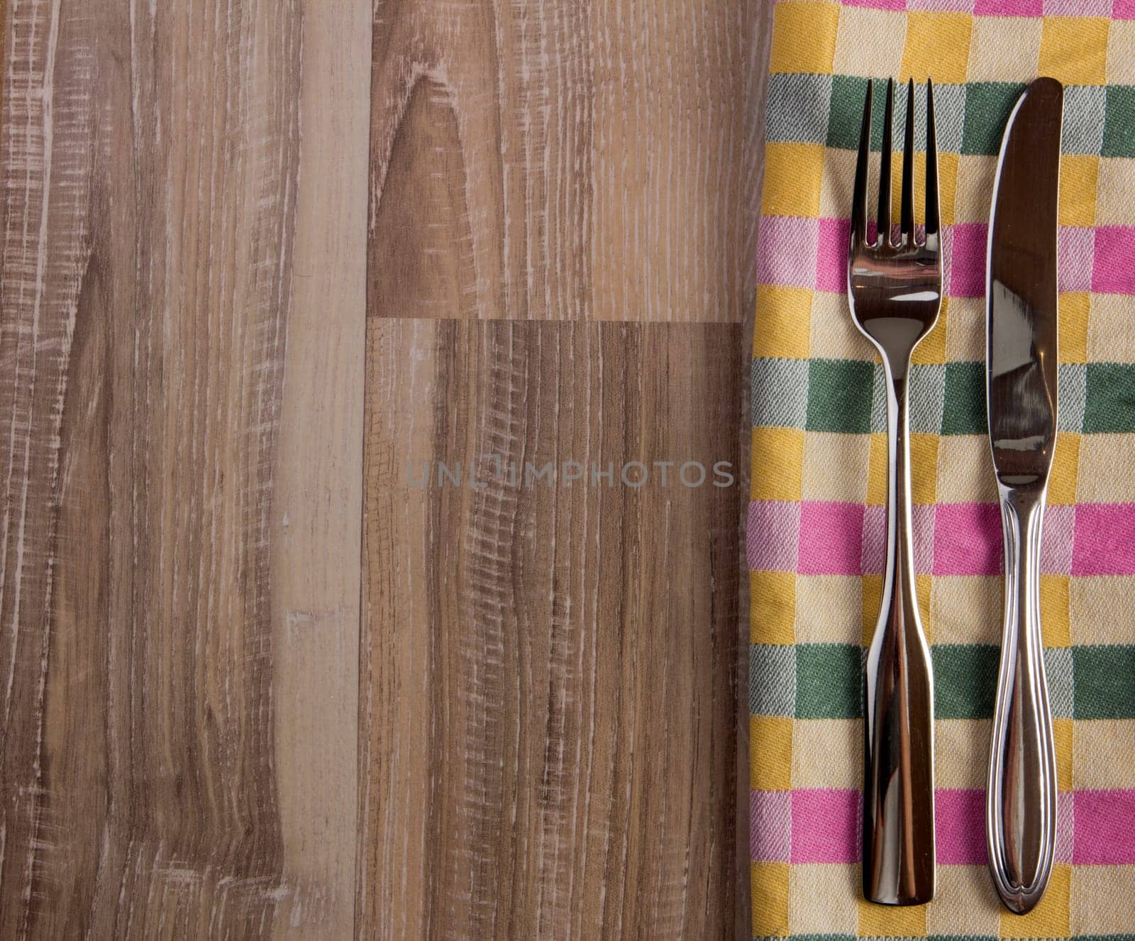 Tableware towel plaid with fork and knife on rustic wooden background
