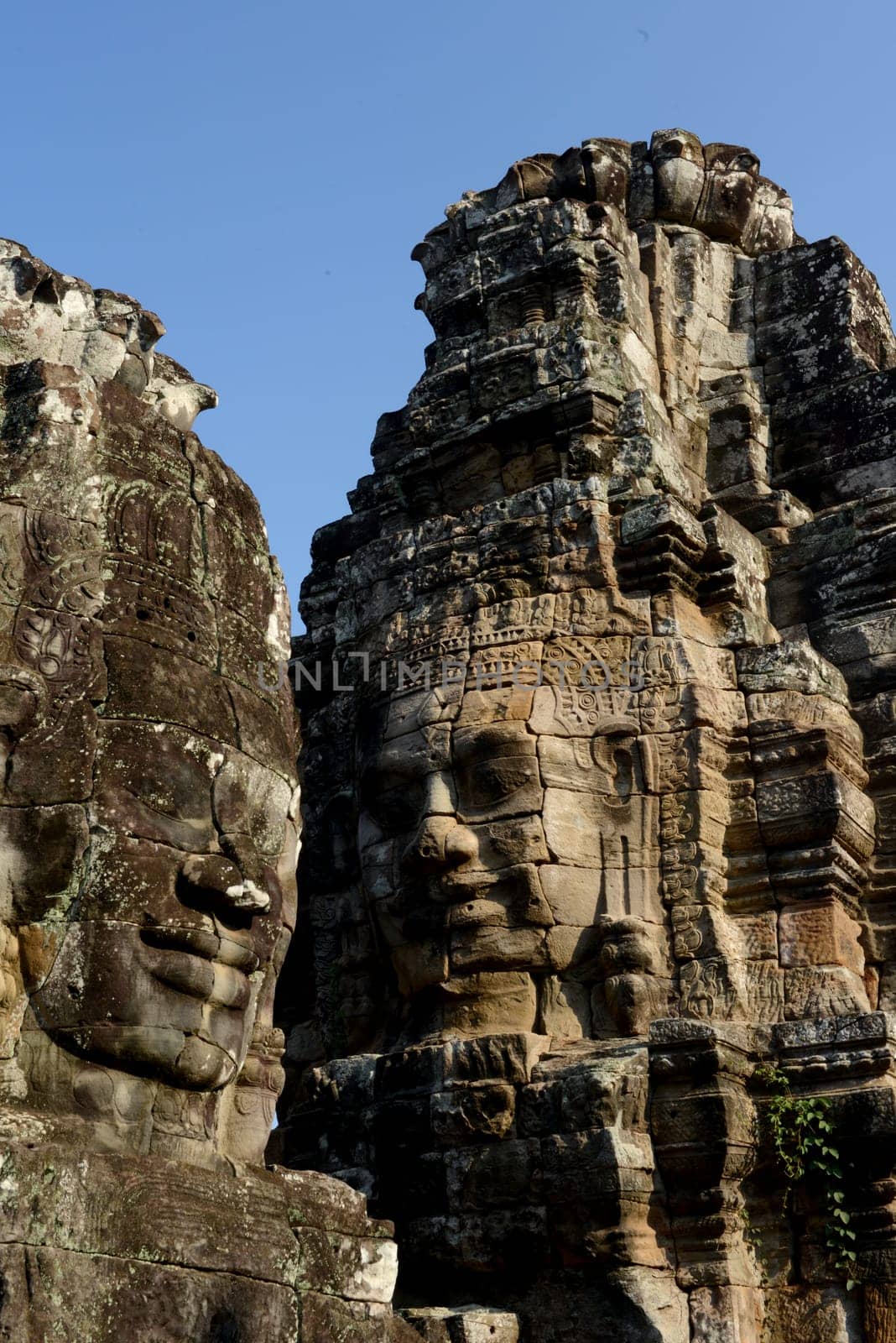 Stone Faces the Tempel Ruin of Angkor Thom in the Temple City of Angkor near the City of Siem Riep in the west of Cambodia.