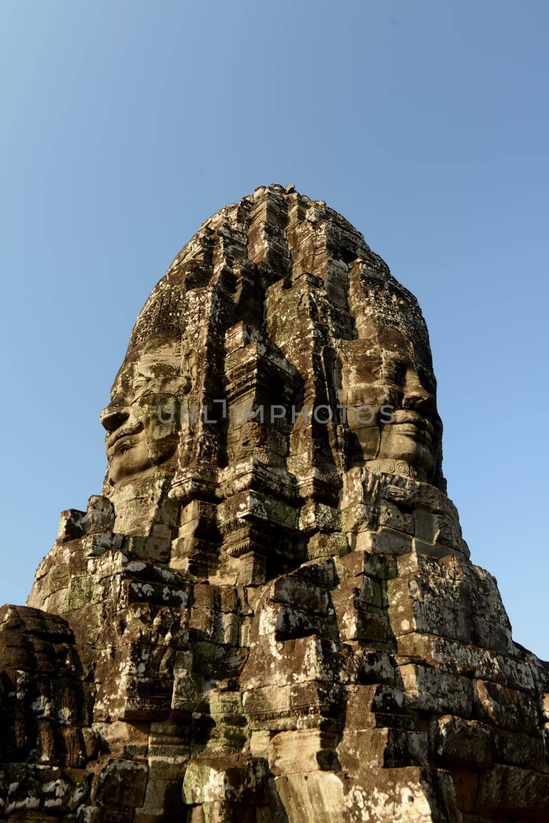 Stone Faces the Tempel Ruin of Angkor Thom in the Temple City of Angkor near the City of Siem Riep in the west of Cambodia.