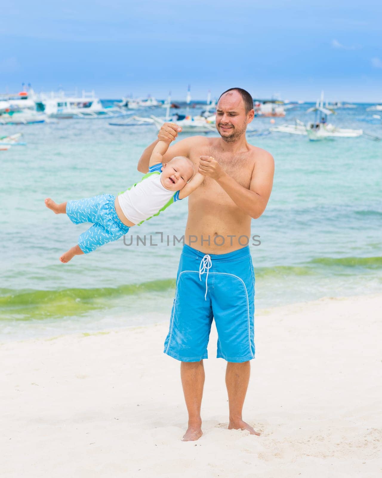 Baby and father on the tropical beach