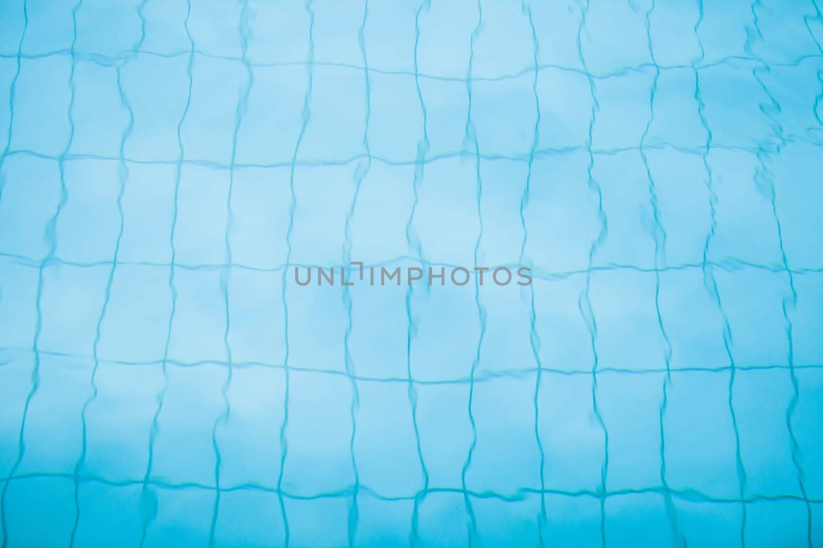 Tiles on bottom of swimming pool distorted slightly by water for background image
