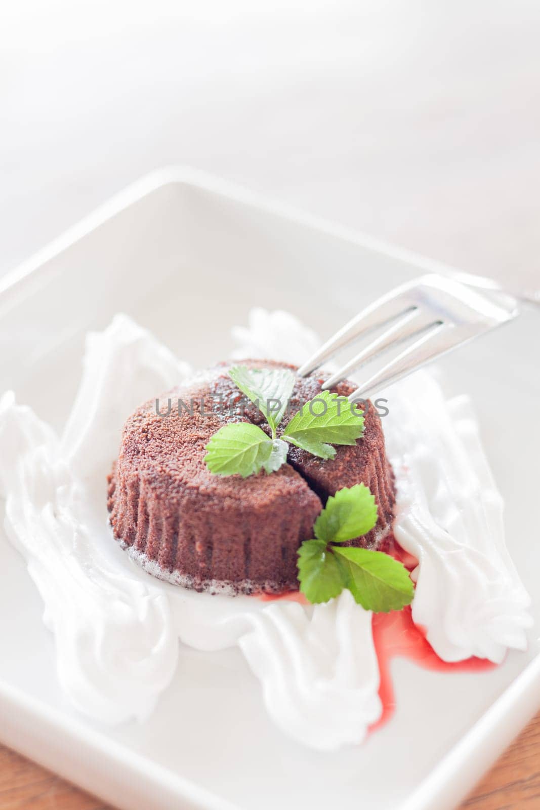 Chocolate lava with whipped cream and strawberry sauce, stock photo
