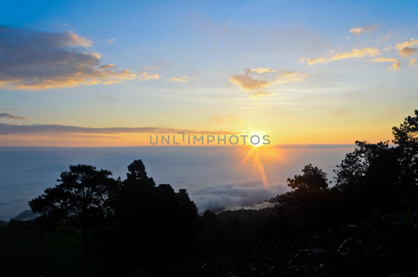 Colorful sunrise above the clouds from high mountain at viewpoint Huai Nam Dang national park in Chiang Mai and Mae Hong Son province of Thailand