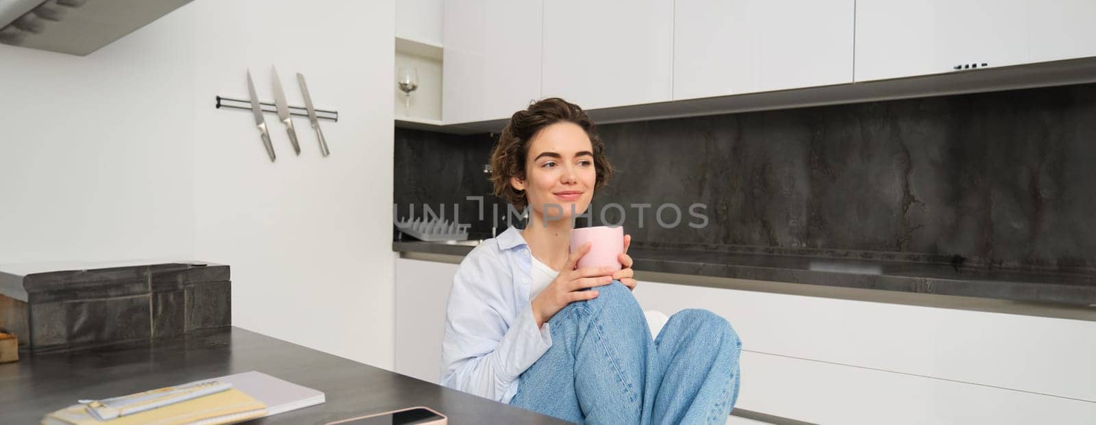 Image of young adult woman with cup of coffee. Girl relaxed at home, drinks tea, has a break from work. People and lifestyle concept