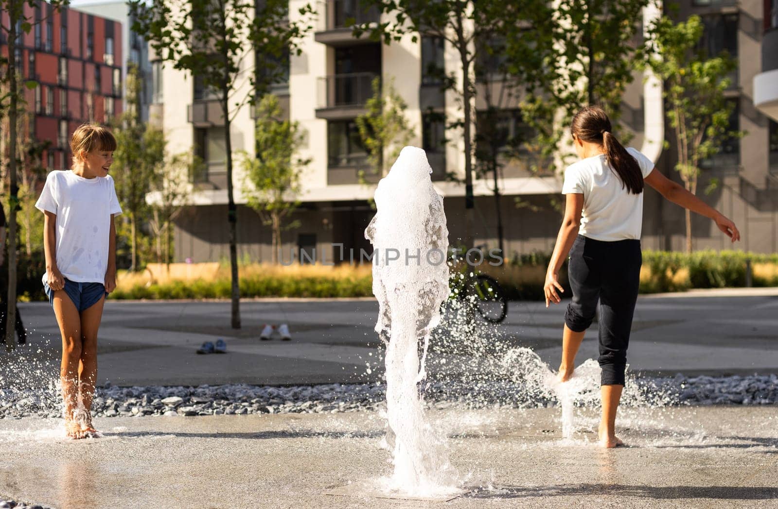 Happy kid playing in a fountain with water. High quality photo