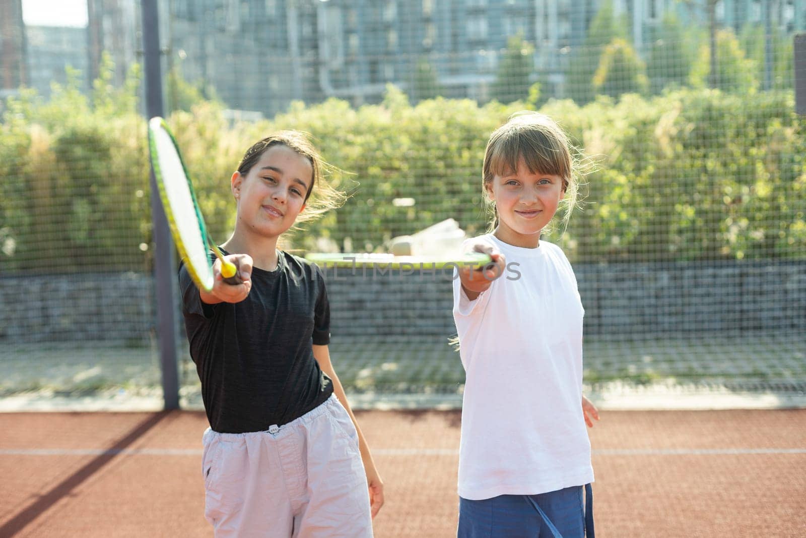 Two girls with badminton rackets on the football field. High quality photo