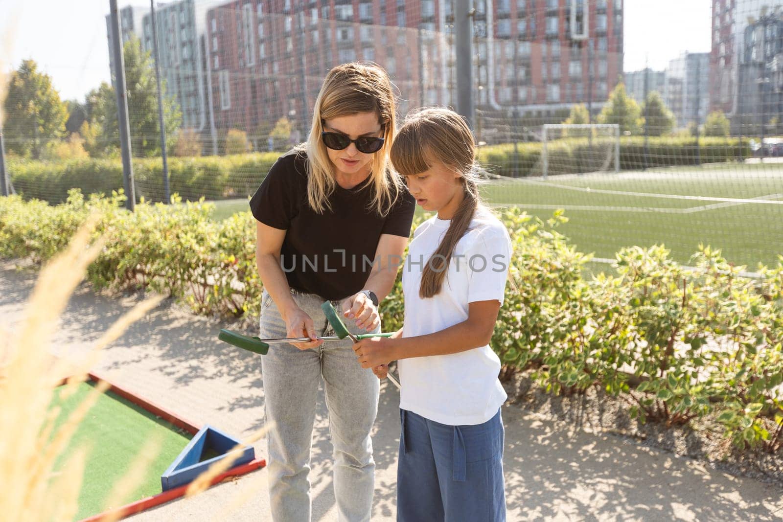 golfers with parents playing golf at sunny day. High quality photo