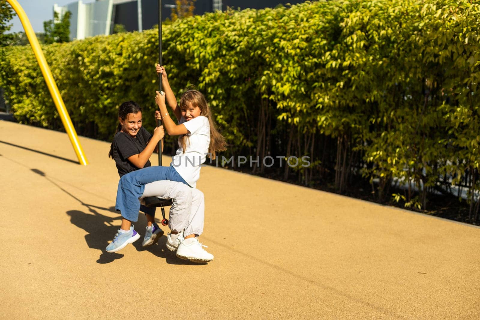 A young girl enjoys the pole ride at the playground runaway, on a warm day. High quality photo