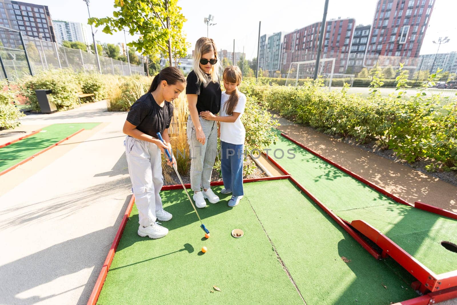 Group of two funny kids playing mini golf, children enjoying summer vacation by Andelov13