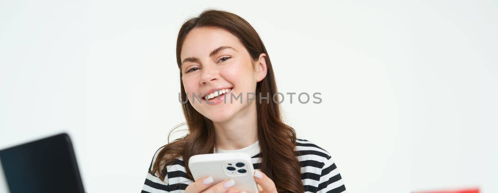 Portrait of girl with smartphone laughing, using mobile phone app, isolated on white background by Benzoix