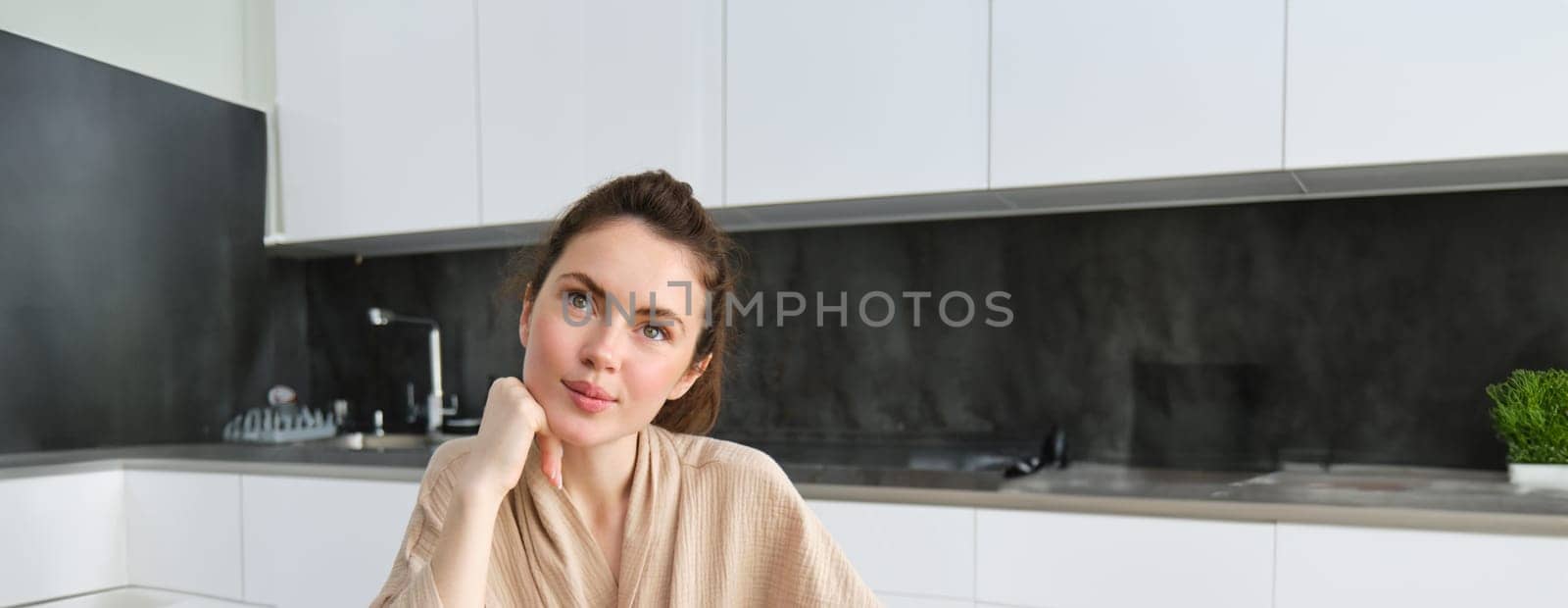Portrait of woman sitting with groceries, making list for shopping, posing near vegetables, preparing food, cooking in the kitchen.
