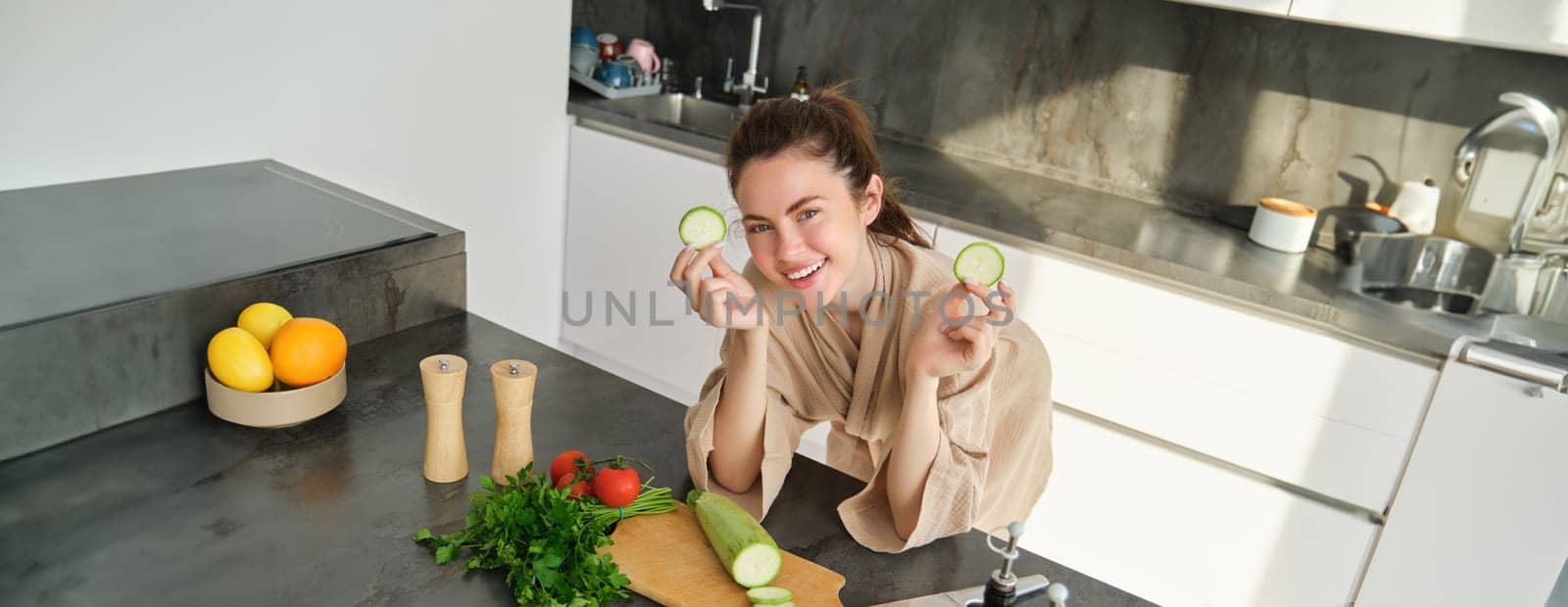 Portrait of good-looking woman cooking salad in the kitchen, chopping vegetables and smiling, preparing healthy meal, leading healthy lifestyle and eating raw food by Benzoix