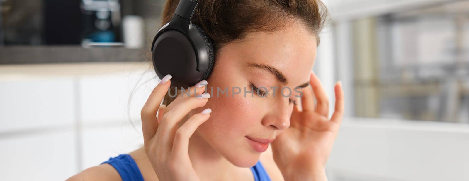 Face of beautiful woman in wireless headphones, enjoys sound, listens to music in wireless headphones.