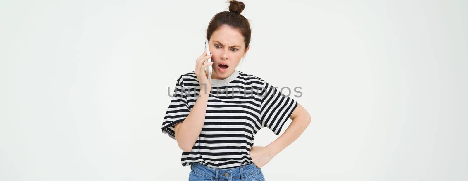 Image of brunette woman arguing, shouting on telephone, having an argument on mobile phone, standing over white background.