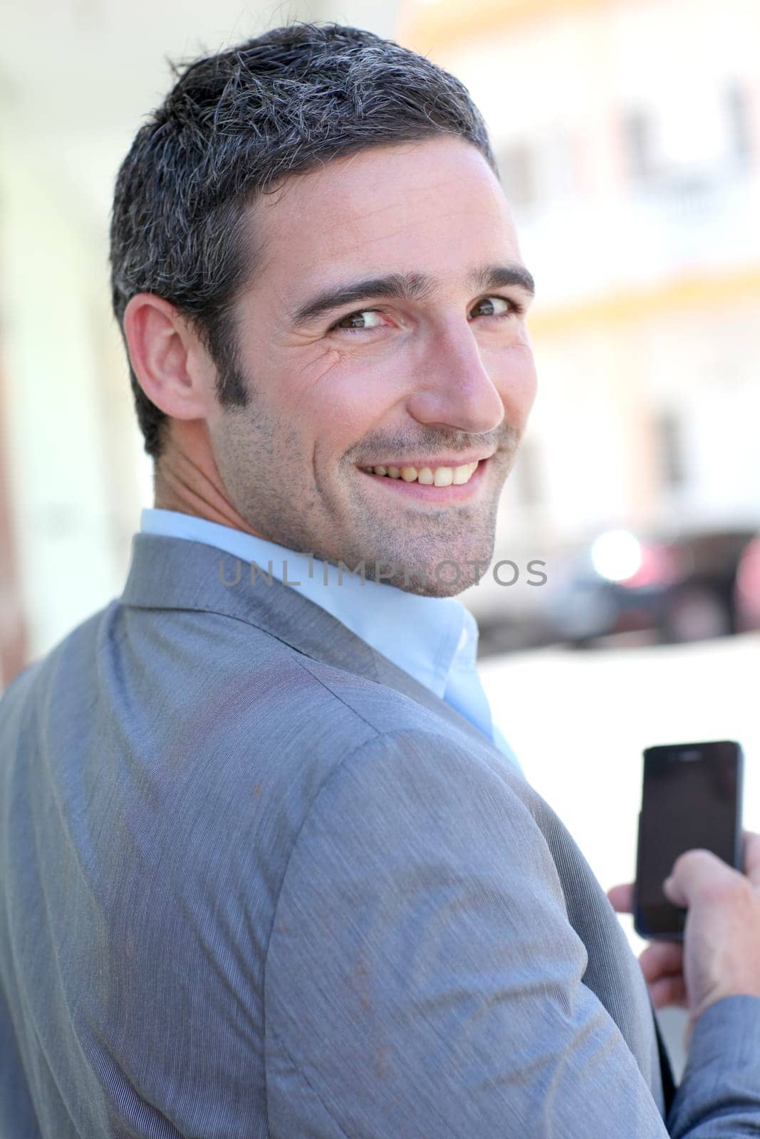 Businessman using mobilephone out in town