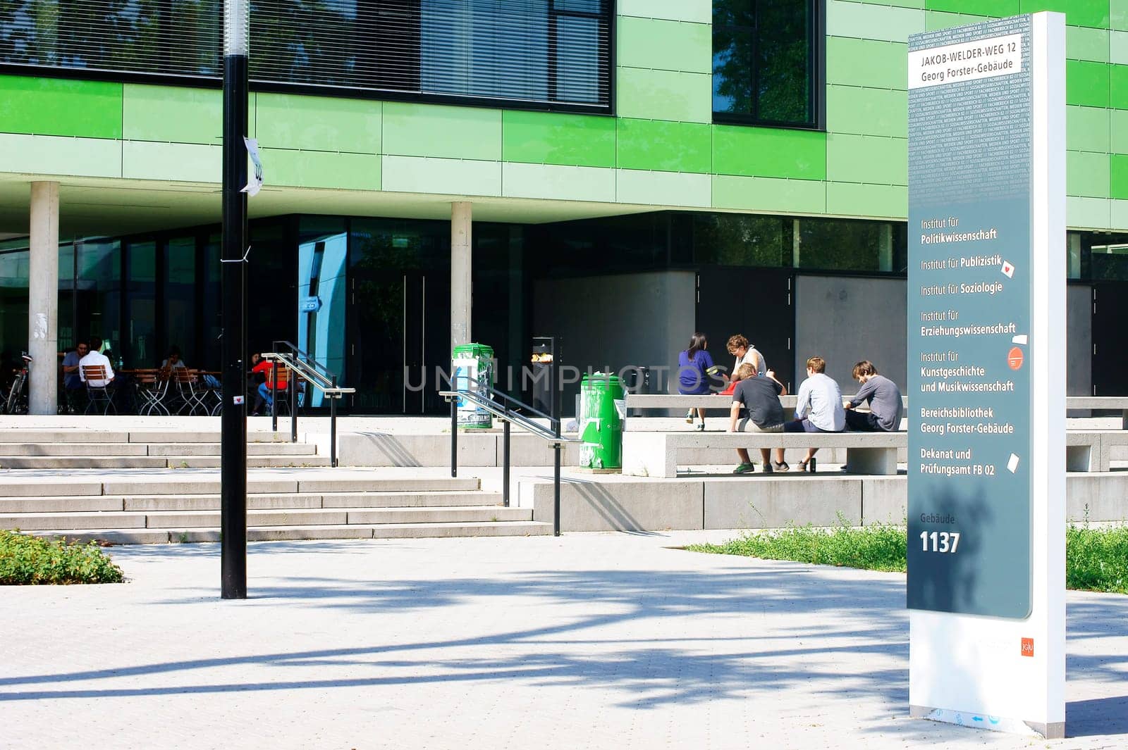 Mainz,Germany – August 09,2014: Students sit in front of the new and modern Georg Forster building on the grounds of Johannes Gutenberg University on August 9,2014 in Mainz.