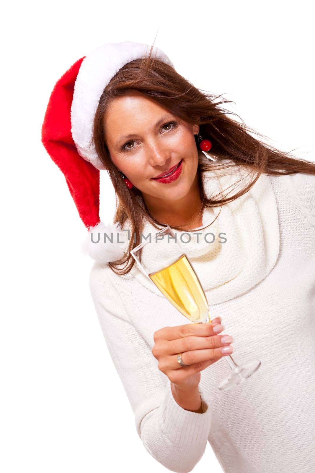 Attractive woman with red Santa hat holds a glass of champagne in her hand and smiles isolated on white background freeing text space