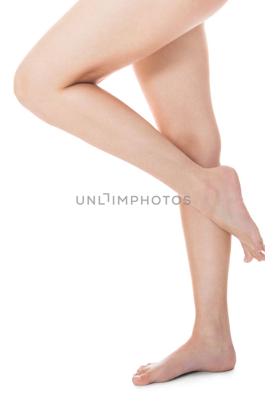 Elegant long shapely naked female legs with bare feet insulated on white with text space
