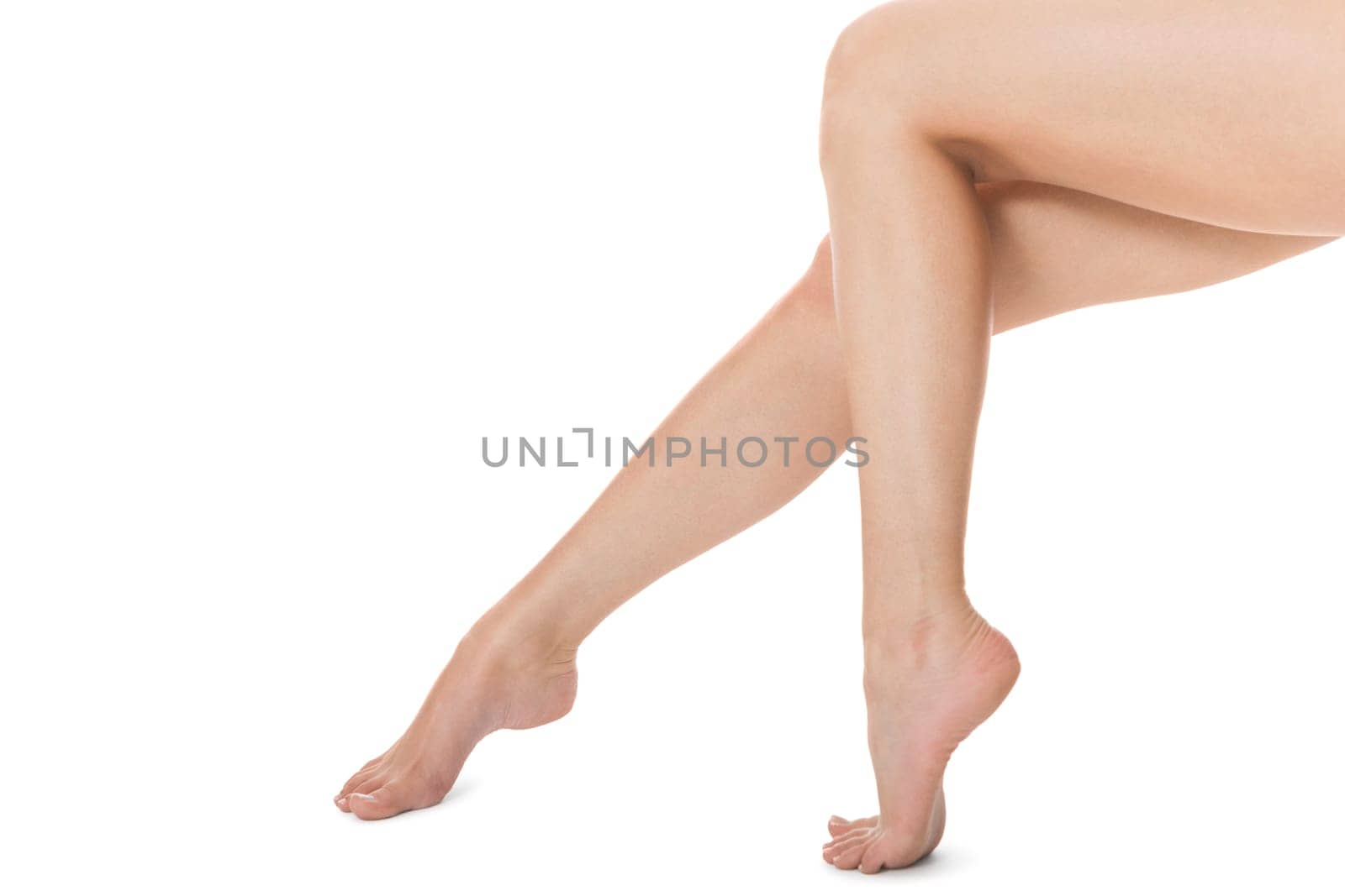 Elegant long shapely naked female legs with bare feet insulated on white with text space
