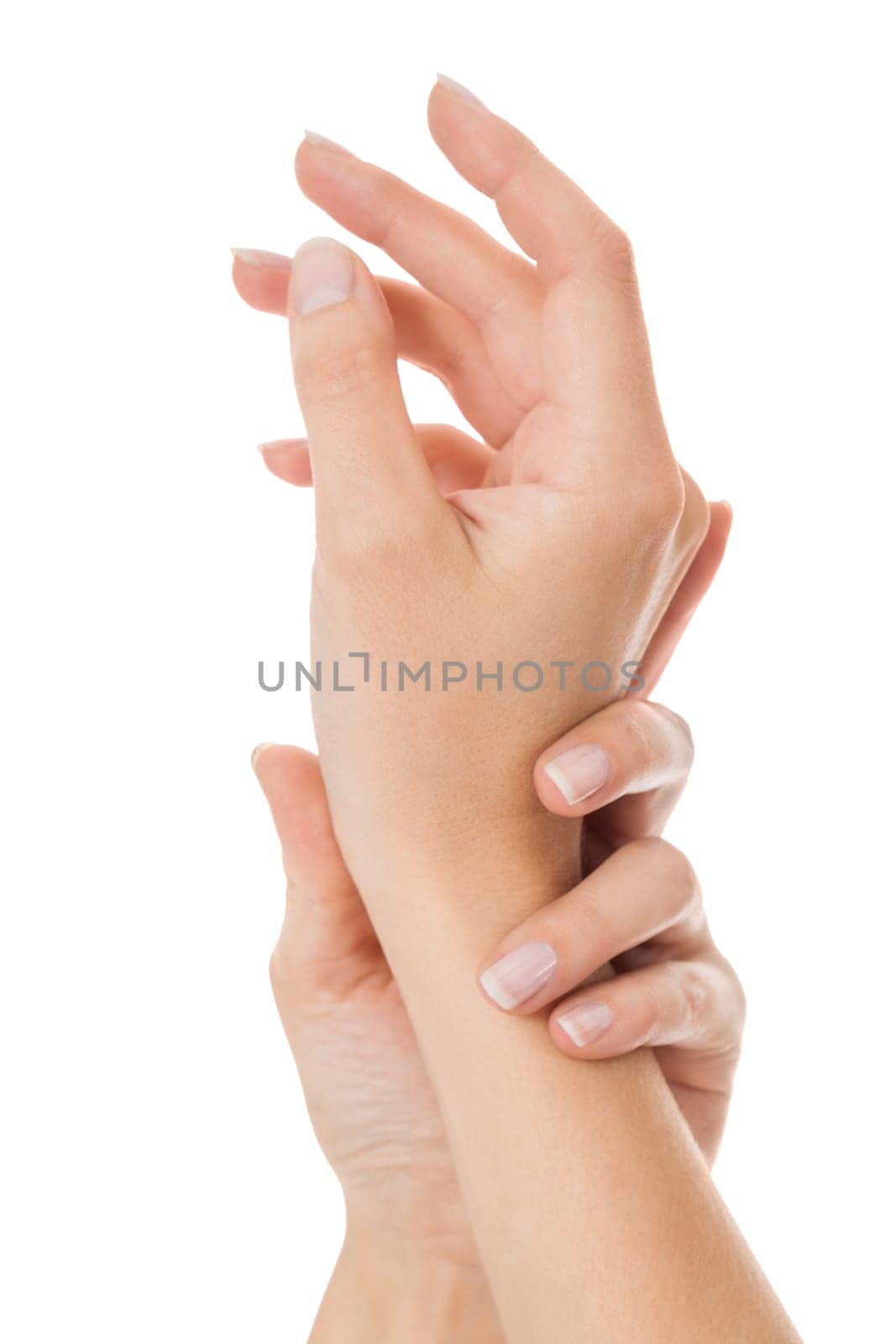 Sensual female hands of a woman with neat natural nails graceful keeps her wrist isolated on white with