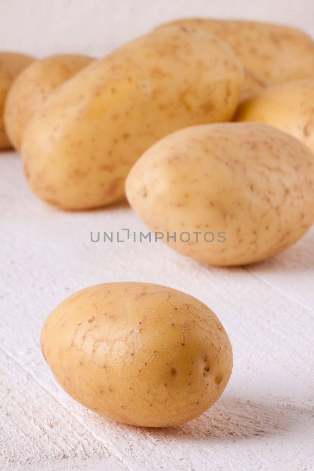 Fresh washed potatoes with peel as a close-up on a rustic wooden board