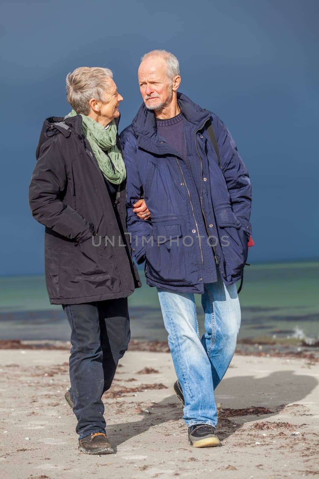 older adult happy couple walks on the beach in autumn lifestyle happiness
