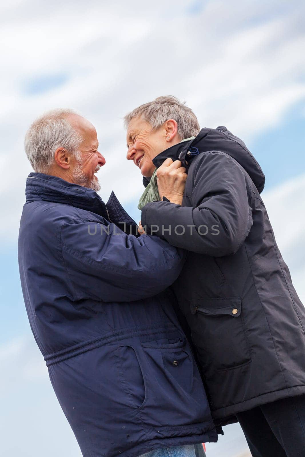 older adult happy couple walks on the beach in autumn lifestyle happiness
