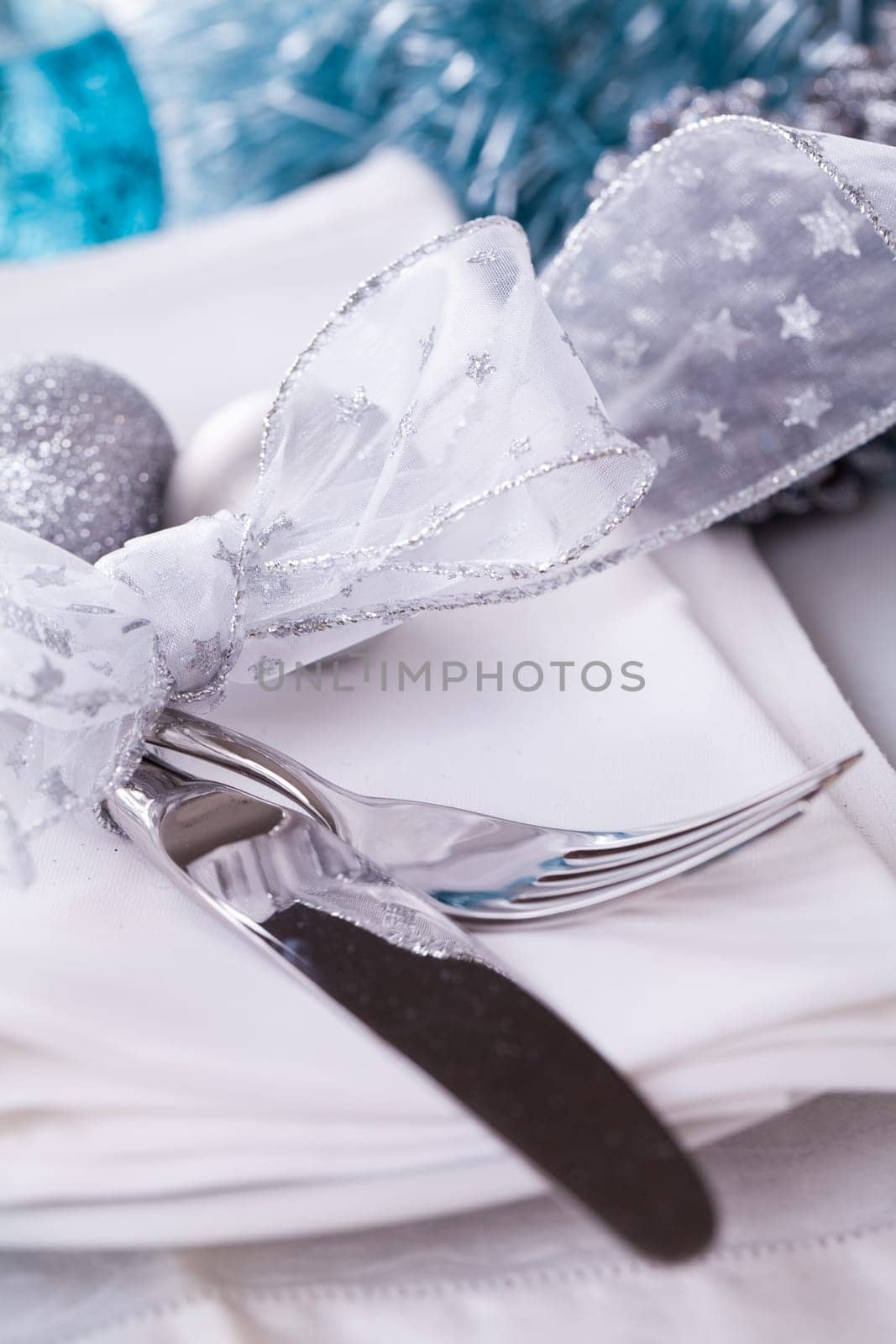 Stylish table with Christmas decoration in turquoise and silver shiny with cutlery